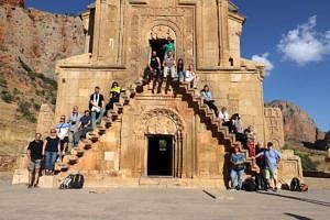 Die Exkursionsgruppe der Erlanger Lehrstühle für Christliche Archäologie sowie Geschichte und Theologie des christlichen Ostens auf der Treppe der Fassade der Klosterkirche von Noravank